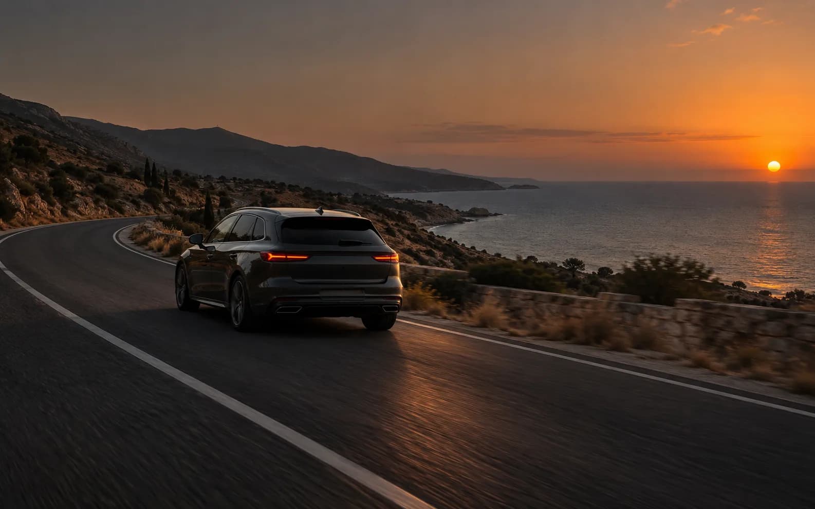 Car travelling on a coastal road in Cyprus at sunset